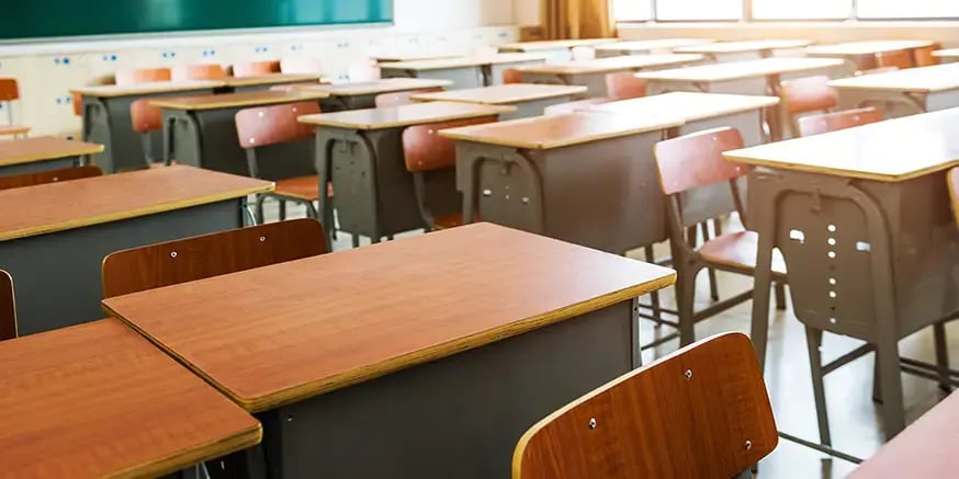 An empty classroom full of empty desks