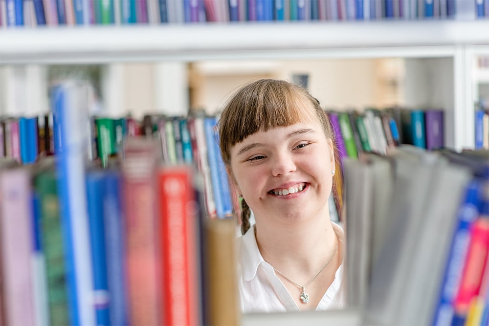 A student among stacks in a SEND school library