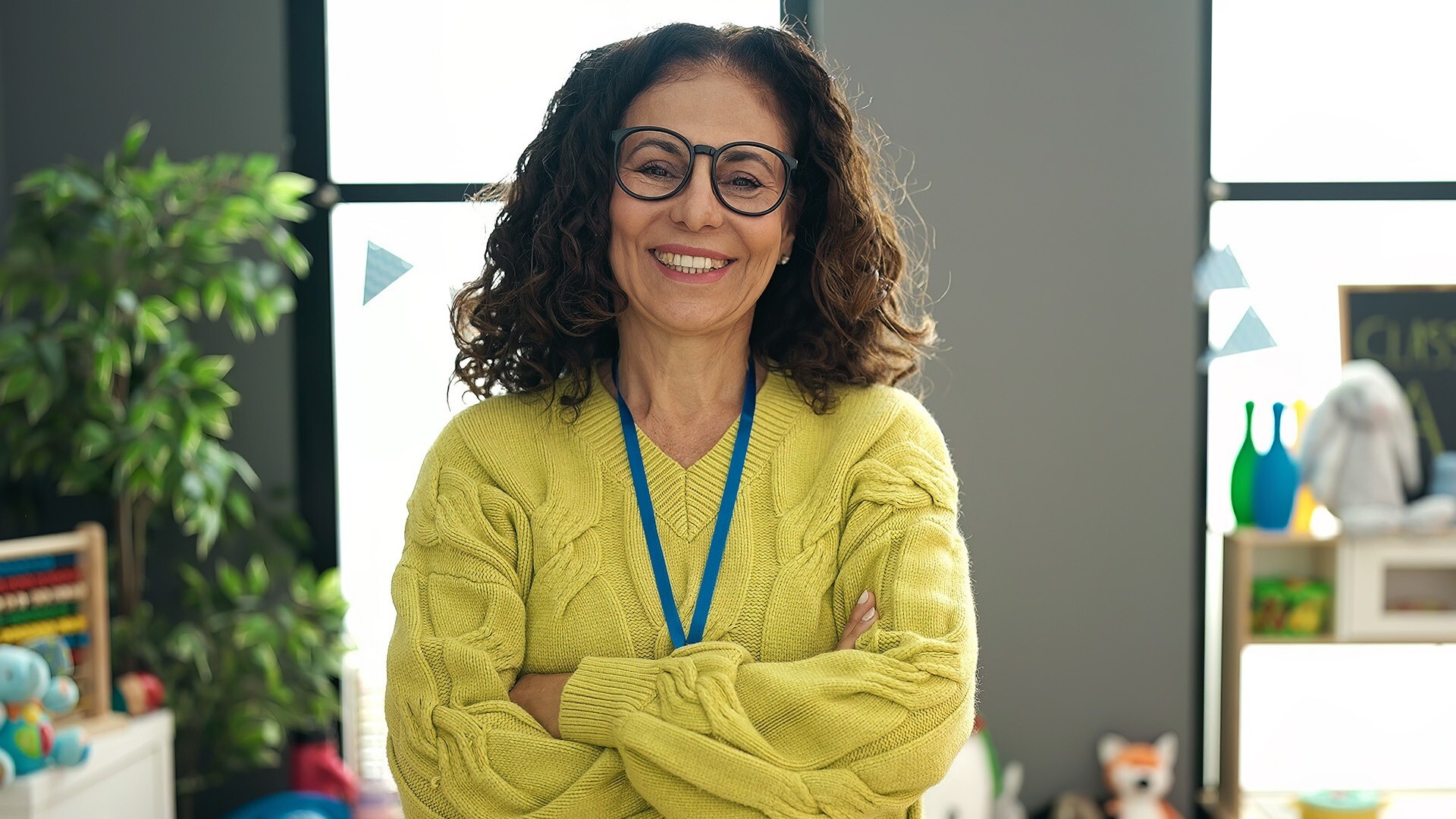 Lady with glasses and yellow top on smiling front on